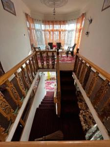古尔马尔格Everest Guest House的房屋内的楼梯,配有椅子和窗户