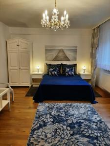 亚斯塔尔尼亚Blisko morza的一间卧室配有蓝色的床和吊灯。