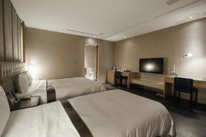 台中市台中之星汽车旅馆 的酒店客房设有两张床和一台平面电视。
