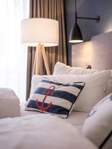 库克斯港伍赫伯格酒店的床上有枕头,上面有红色的锚