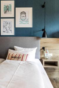 库克斯港伍赫伯格酒店的卧室配有白色的床,墙上挂着一些图片