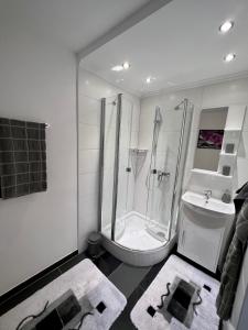 施奥弗灵Apartment 1 Gäste的带淋浴和盥洗盆的白色浴室