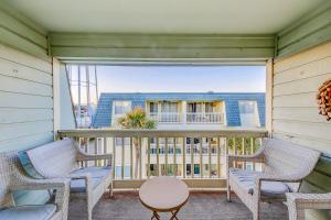 棕榈岛Oceanside 308-B的阳台配有2把椅子和桌子
