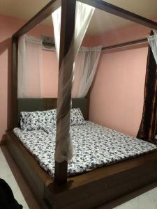 NaicLuzville Residences - C8的卧室内的一张带天蓬的床