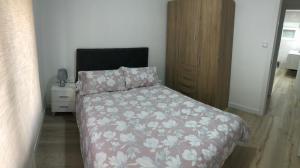 萨莫拉PARQUE DE LA MARINA ESPAÑOLA的一间卧室配有一张带花卉床罩和床头柜的床。