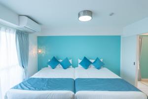 名古屋Fuchsia - Vacation STAY 08005v的蓝色卧室配有一张带蓝色枕头的大床