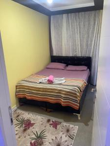 Çiftlikköyİmperyum park vilları的一间卧室,配有一张带粉色帽子的床