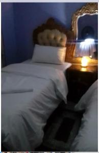 奇帕塔Faigib Guest House的卧室配有白色的床和带灯的床头柜