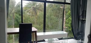 TayabasA House Lucban Resort & Spa的享有棕榈树景致的大窗户