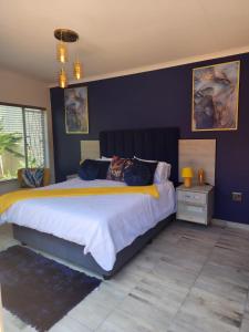 布隆方丹SiBella guest house的一间卧室设有一张蓝色墙壁的大床