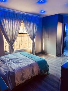PimvilleMndazi Manor的一间卧室配有床和带窗帘的窗户