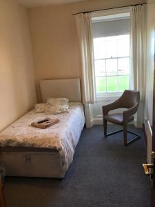 哈特尔普尔Sea View Guest House的卧室配有床、椅子和窗户。