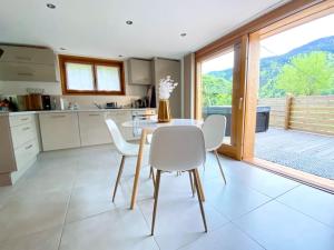 Les Villards-sur-ThônesAndrosace Appartement dans Chalet bois avec Jacuzzi privatif Terrasse et Vue Montagne的一个带桌椅和大窗户的厨房