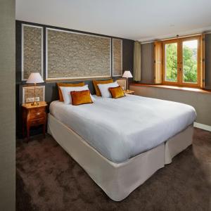 圣瓦斯特拉乌格Hotel de France的卧室配有带橙色枕头的大型白色床