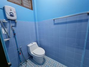 清莱หอพักโชคอนันต์的一间带卫生间的浴室和蓝色瓷砖墙