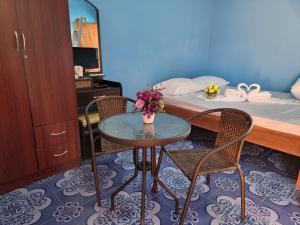 清莱หอพักโชคอนันต์的配有桌子和两把椅子及一张床的房间