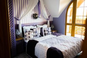 维斯瓦卡罗洛多尔酒店的一间卧室配有一张紫色墙壁和窗户的床