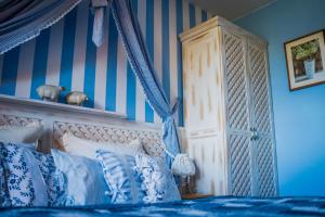 维斯瓦卡罗洛多尔酒店的一间卧室配有一张蓝色和白色条纹的床
