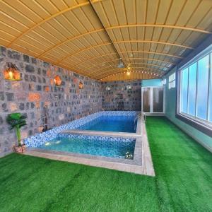 Sayqalreaambreather2的绿色草坪房子中的游泳池