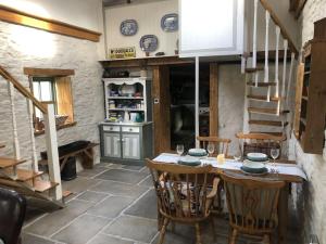 罗斯克里Hopesgate Cottage - Roscrea的一间带桌椅和楼梯的厨房