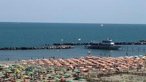 里米尼罗萨蒂酒店的海滩上一大群遮阳伞和一艘船