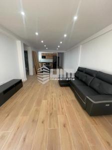 萨贡托UIM Mediterraneo Conqueridor Wifi的客厅设有黑色沙发和木地板