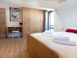博萨迪法萨Chalet Relax的一间卧室配有两张床和一张书桌