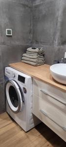 海乌姆Apartament z widokiem的一间带盥洗盆的浴室内的洗衣机