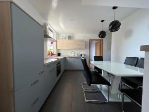 伊德里亚Apartment Sofia的白色的厨房配有桌子和黑色椅子