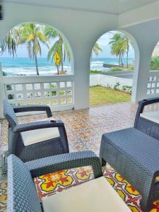 圣安德烈斯Puesta del Sol Guest House的配有椅子并享有海滩景致的客房