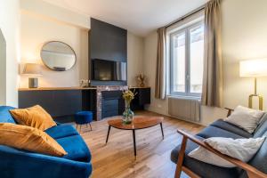 旺多姆L'Orée du Faubourg - VENDOME CENTRE的客厅配有蓝色的沙发和桌子
