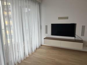 维也纳新城Luxusappartement mit Garage im Zentrum的客厅配有平面电视和大窗户。