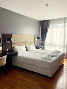 邦涛海滩The Regent Bangtao Apartments的卧室配有一张白色大床和一张书桌