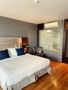 邦涛海滩The Regent Bangtao Apartments的卧室配有一张白色大床和一把椅子
