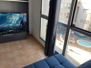 加尔达尔MARTSARAs PISCINA SARDINA的客厅配有蓝色的沙发和平面电视。