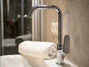 迈尔霍芬Appartements ALMA的浴室水槽配有水龙头和毛巾