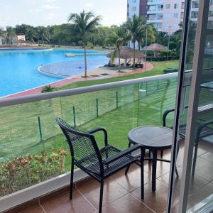 坎昆Departamento 'Hozanek' en Dream Lagoons Cancun的一个带桌椅的阳台和一个游泳池