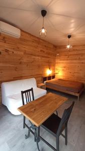 马赛Le chalet de La Treille的客房设有两张床和一张木桌及椅子。