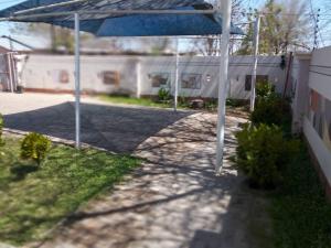 卡萨内Chiloto Guest House的庭院里设有蓝色遮阳伞