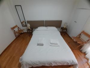 沃洛斯Central Mark-Δωμάτια Διαμερίσματος的卧室配有白色的床和2条毛巾