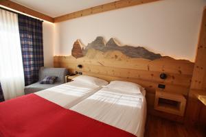 科尔蒂纳丹佩佐Hotel Des Alpes的酒店客房,设有床铺和壁画