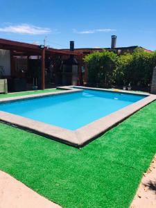 伊基克Casa con Piscina privada en Pica的绿色草地大型蓝色游泳池