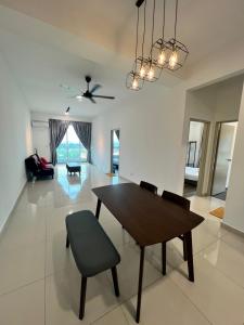 怡保Spacious Family Staycation 3BR at Ipoh Uptown的用餐室以及带桌椅的起居室。