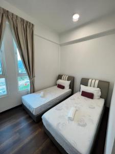 怡保Spacious Family Staycation 3BR at Ipoh Uptown的带窗户的客房内的两张床