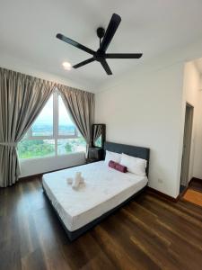 怡保Spacious Family Staycation 3BR at Ipoh Uptown的一间卧室配有一张大床和吊扇