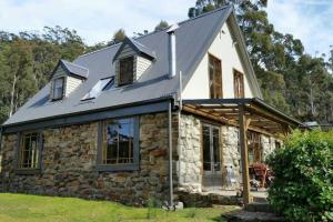 Simpsons BayThe Stone Cottage - Bruny Island的一座石头房子,有金属屋顶