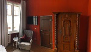 EllingenGasthof Römischer Kaiser的卧室设有红色的墙壁、门和椅子