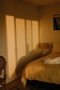 吉斯伯恩Tatapouri Bay的一间卧室配有一张床和一个带百叶窗的窗户