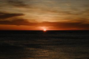吉斯伯恩Tatapouri Bay的远方的太阳在海上的日落