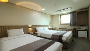 首尔东大门金城大酒店的酒店客房设有两张床和窗户。